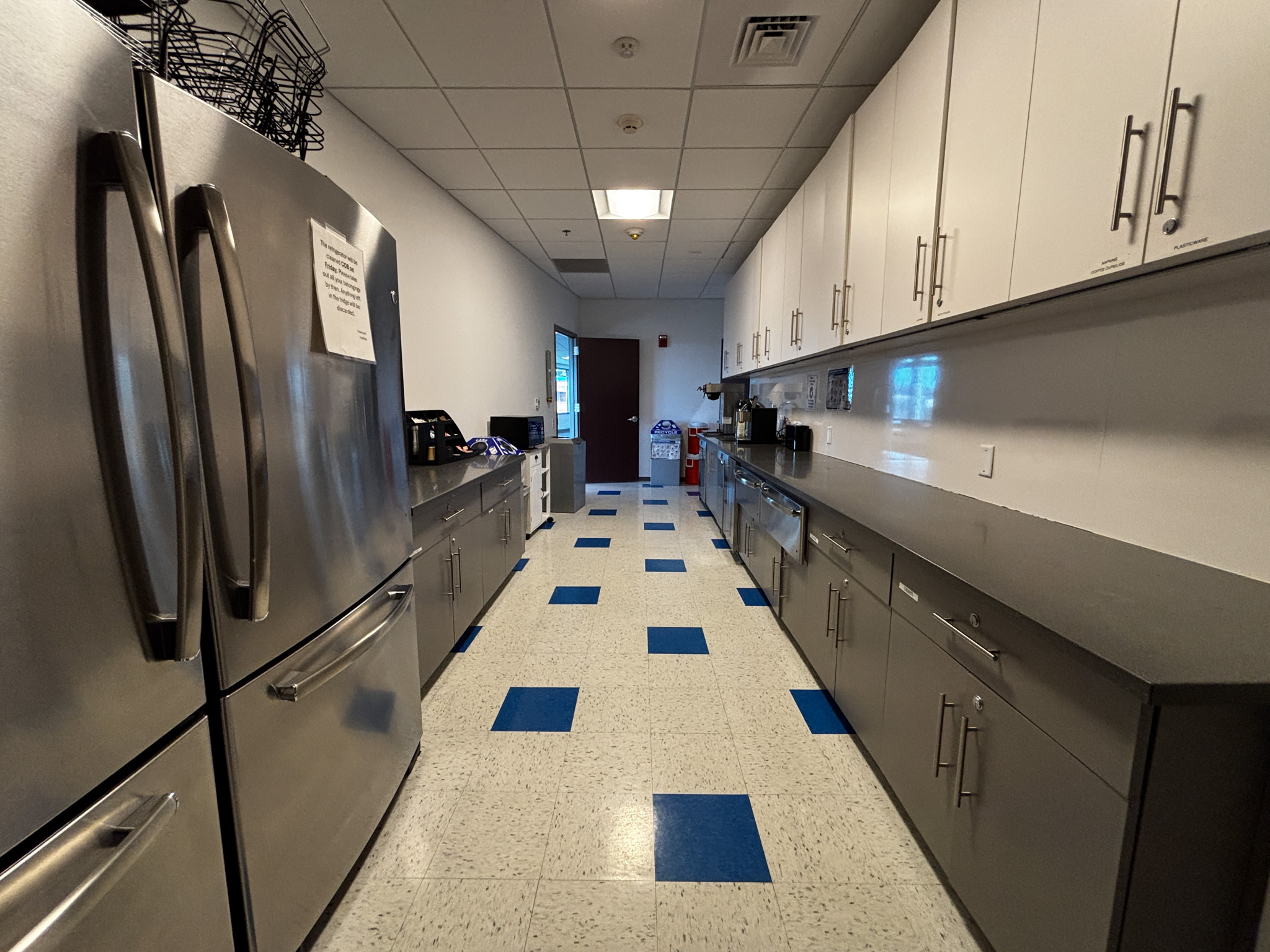 Galley kitchen with blue and white tiles.