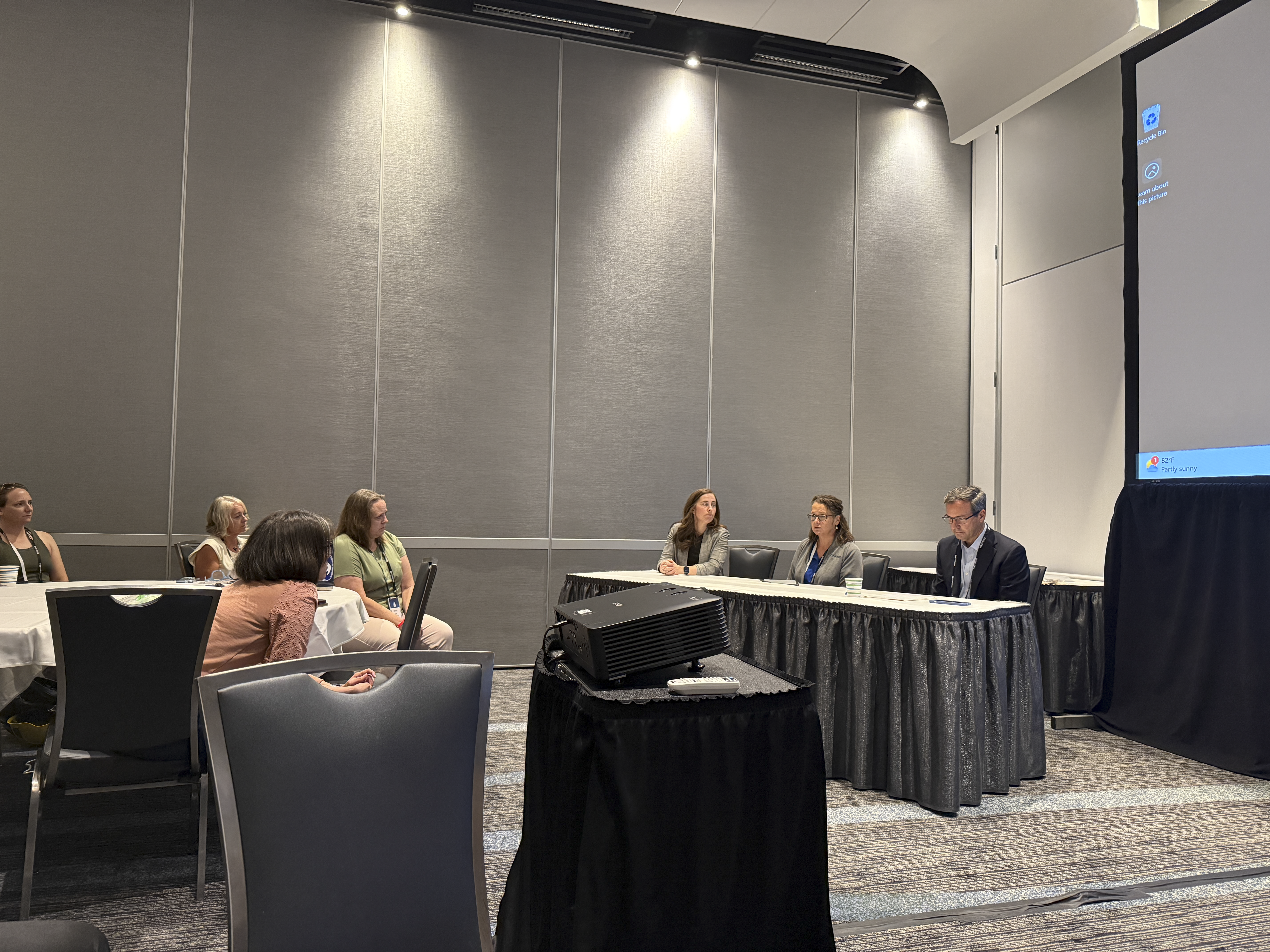 Three speakers on a panel at a conference.